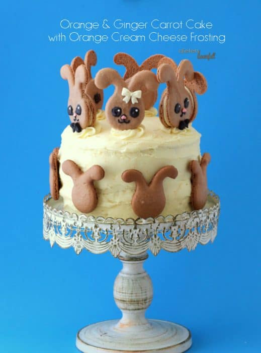 Layered carrot cake on a cake pedestal with chocolate bunny decorations