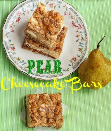 Pear Cheesecake Bars stacked on a plate next to another bar and a whole pear