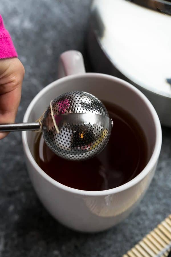 Overhead view of a tea ball over a mug of tea