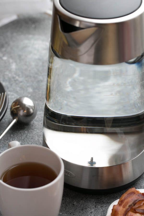 Oxo kettle with water in front of a cup of tea