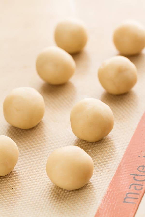 Shortbread dough balls on a baking mat