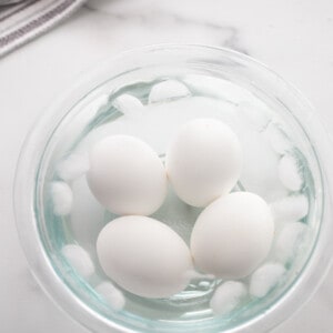 Four Hard Boiled Eggs in a Glass Bowl Filled with Ice Water