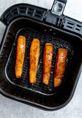 Top view of four air fried salmon in the air fryer basket