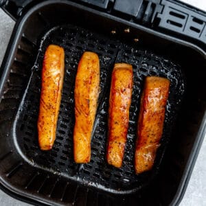 Top view of four air fried salmon in the air fryer basket