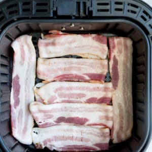 Seven Pieces of Raw Nitrate-Free Bacon in an Air Fryer Basket