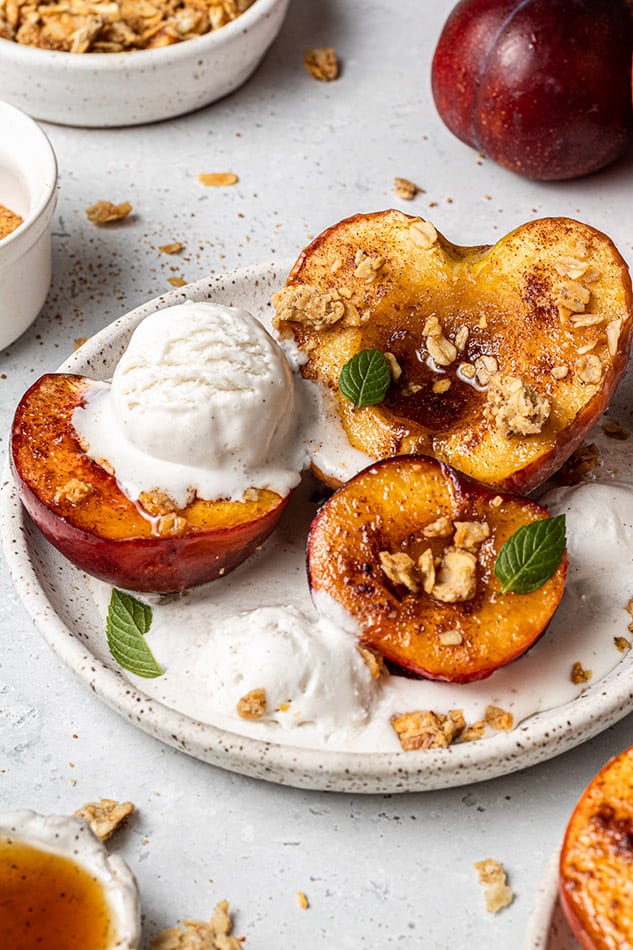 Close-up of air fryer baked fruit on a plate with vanilla ice cream and granola