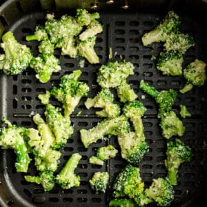 Top view of raw broccoli in the air fryer basket