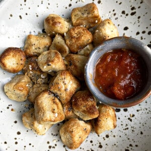 A Plate of Cauliflower Gnocchi with a Small Jar of Marinara Sauce on the Side