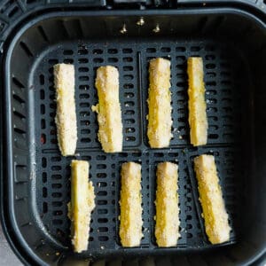 Top view of 8 air fryer zucchini fries in an air fryer basket