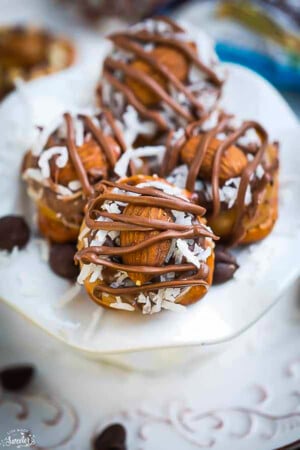 Four Almond Joy Rolo Pretzel Bites on a white plate.