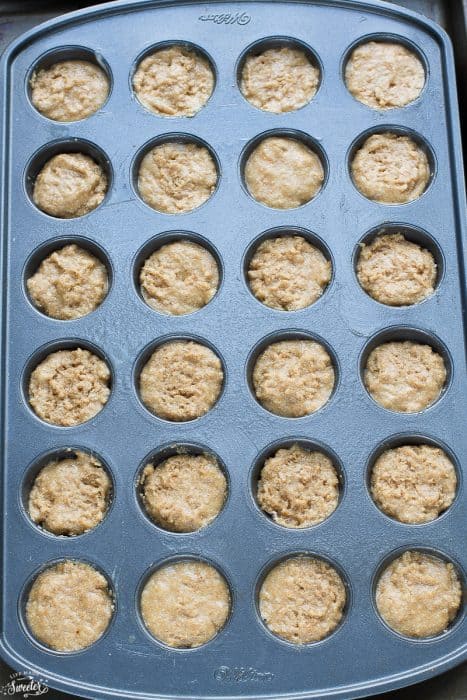 Top view of apple donut hole batter in a mini 24 count muffin pan