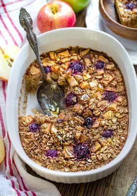 apple cinnamon baked oatmeal in a casserole dish with spoon for serving