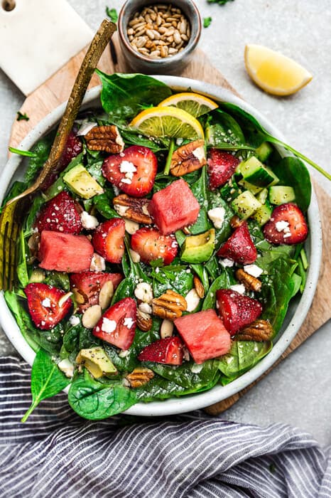 Overhead view of Arugula Watermelon Feta Salad with Strawberries in a bowl