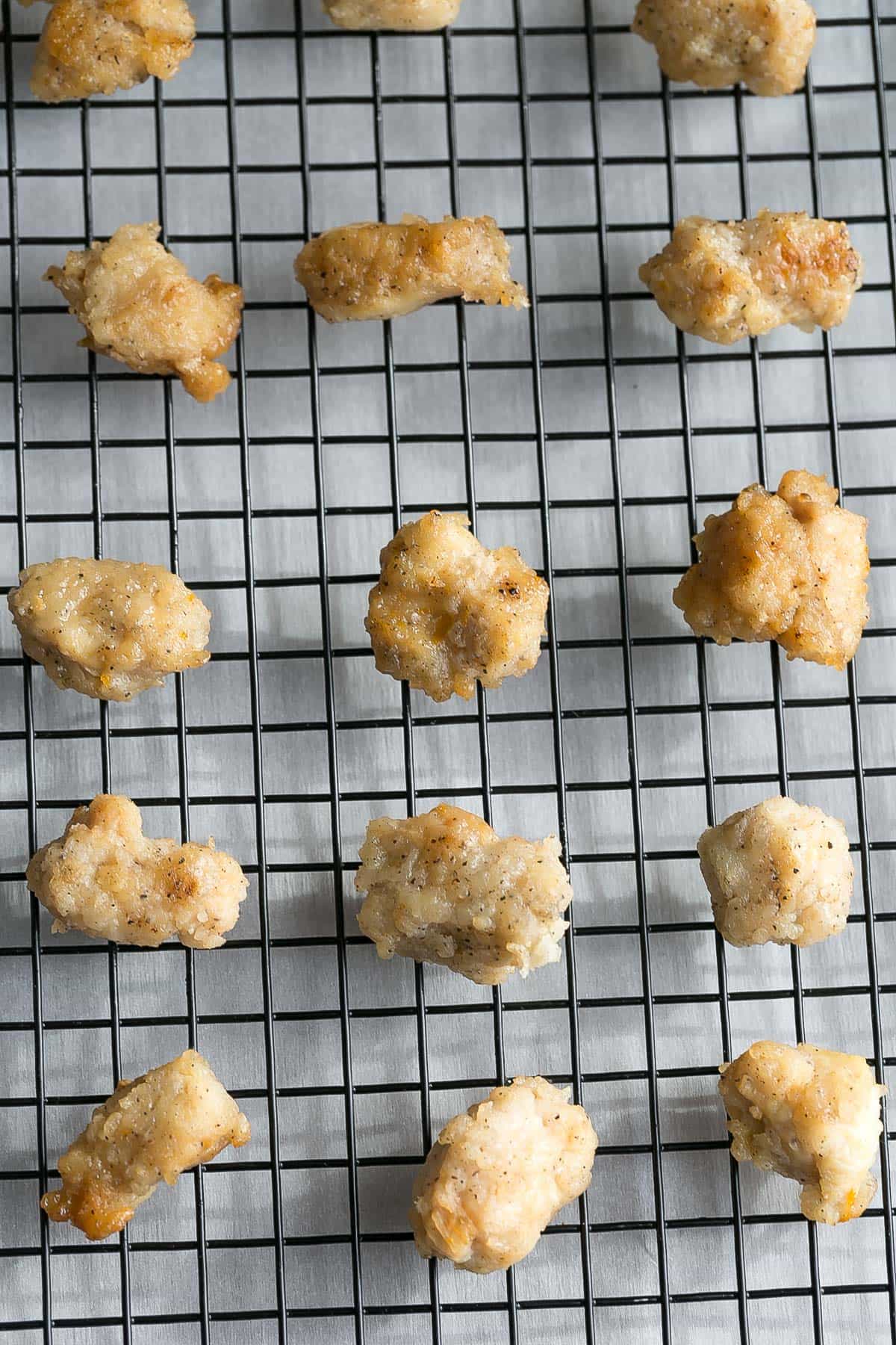 Overhead view of cooked breaded chicken bites on a wire rack
