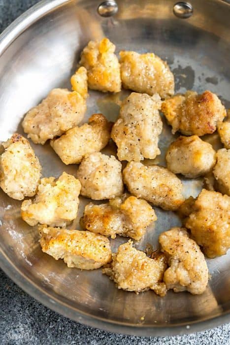 Breaded chicken bites cooking in a skillet
