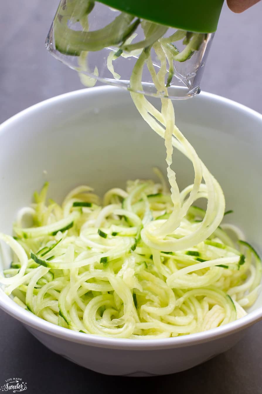 Close up view of spiralized zucchini noodles in a white bowl