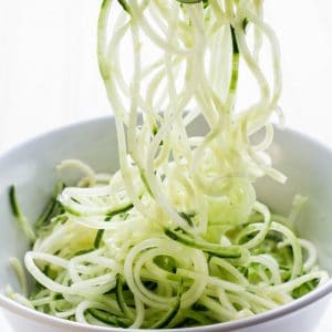 Close up view of spiralized zucchini noodles in a white bowl