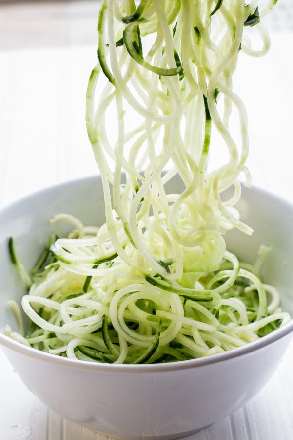 Front view of cucumber zoodles in white bowl.