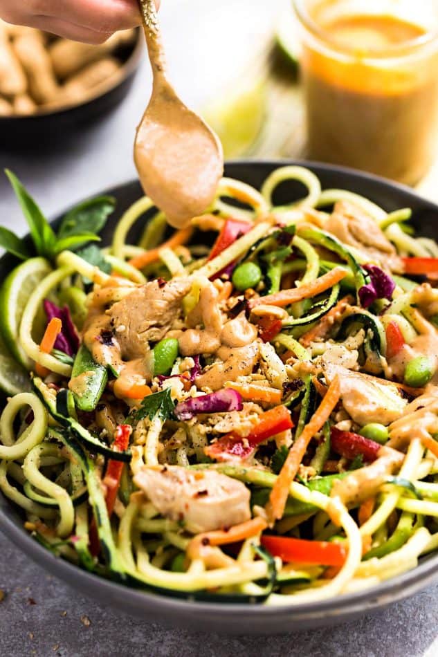 Thai Peanut Dressing being drizzled over Asian Zucchini Noodle Salad