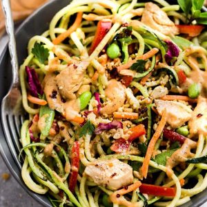 Top view of a large serving bowl of Asian noodle salad with chicken and vegetables