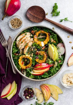 Top view of Autumn Harvest Salad with apple, pear and chicken in a bowl with forks