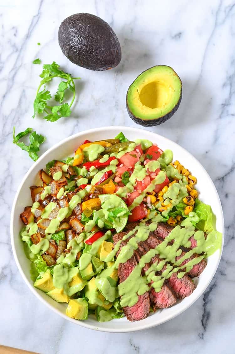 Overhead view of Avocado Steak Salad in a bowl drizzled with avocado dressing