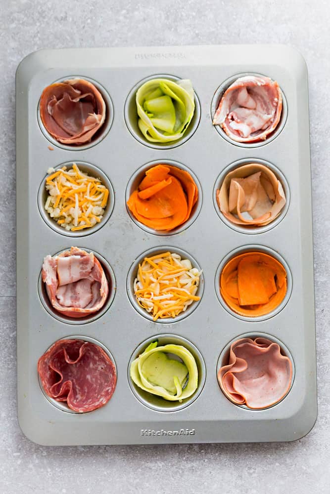 Uncooked baked egg cups in a 12-cup muffin tin