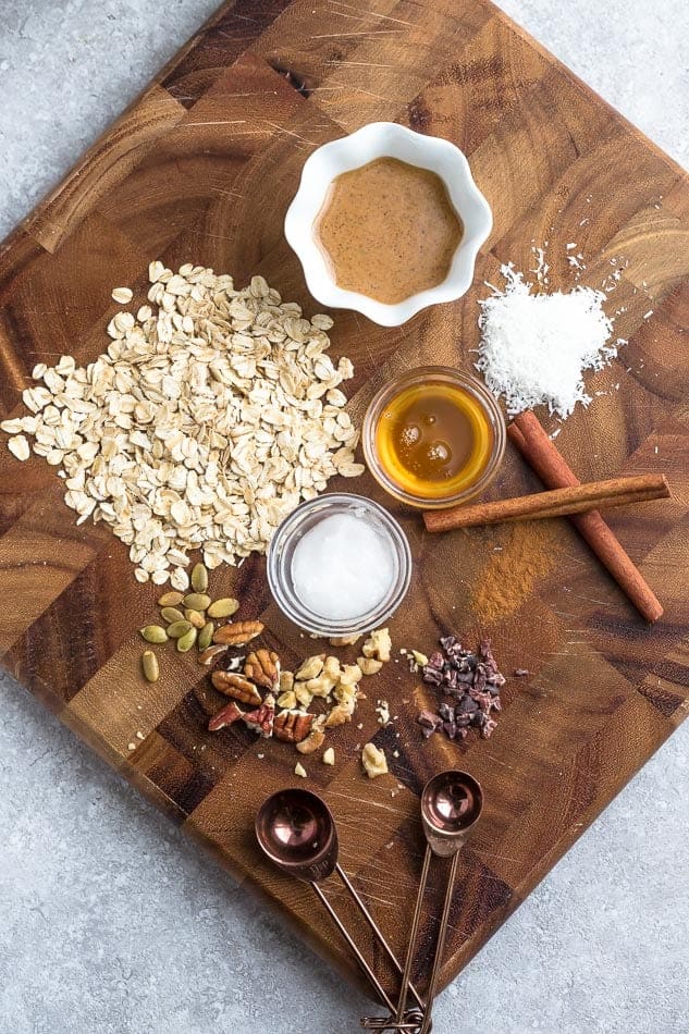 Rolled Oats, Maple Syrup and The Rest of the Oatmeal Cup Ingredients on a Wooden Cutting Board