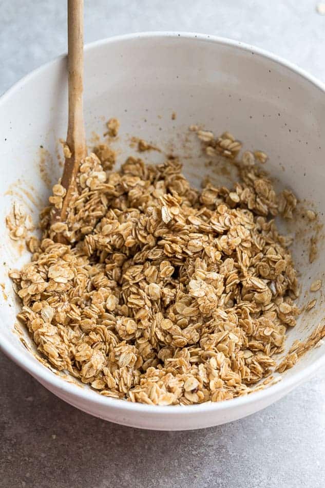 Top view of bowl with oats and a wooden spatula to make baked oatmeal