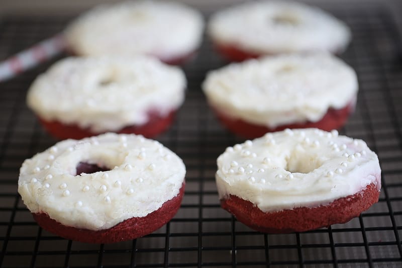 Baked Red Velvet Cake Donuts with Cream Cheese Glaze on a cooling rack