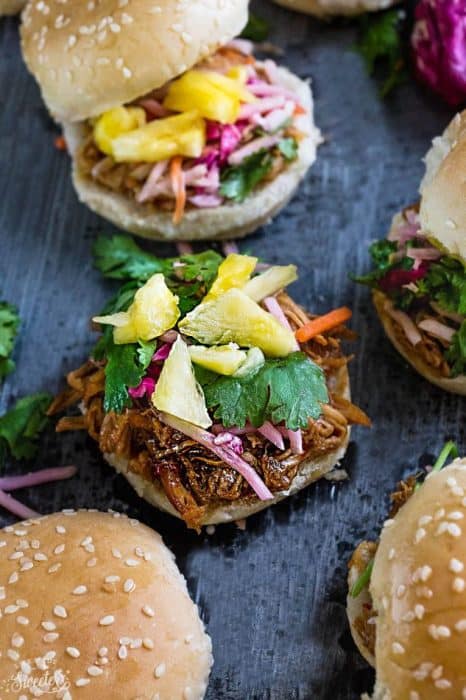 Balsamic Honey Pulled Pork Sliders make the perfect easy dinner or game day party appetizers! Best of all, the soft and tender pork comes together easily in the slow cooker or the oven so you can still watch the football game while these cook up!