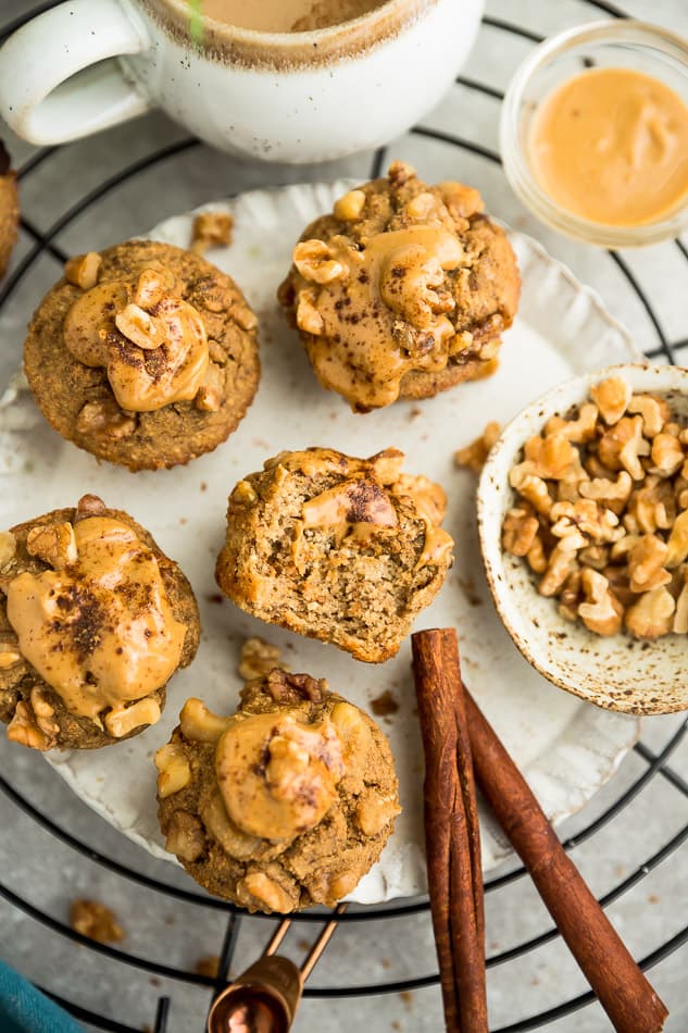 Top view of keto muffins with almond butter and walnuts on white plate.