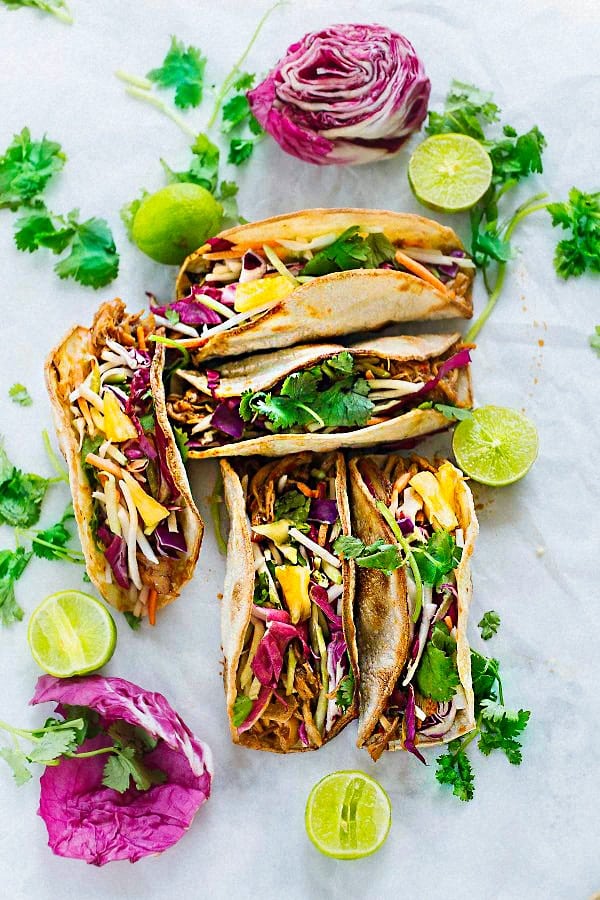 Overhead view of several Tropical Bahn Mi Tacos filled with pulled pork, pickled vegetables, and pineapple