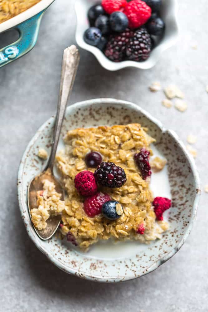 a bowl of baked oatmeal topped with fresh berries and milk