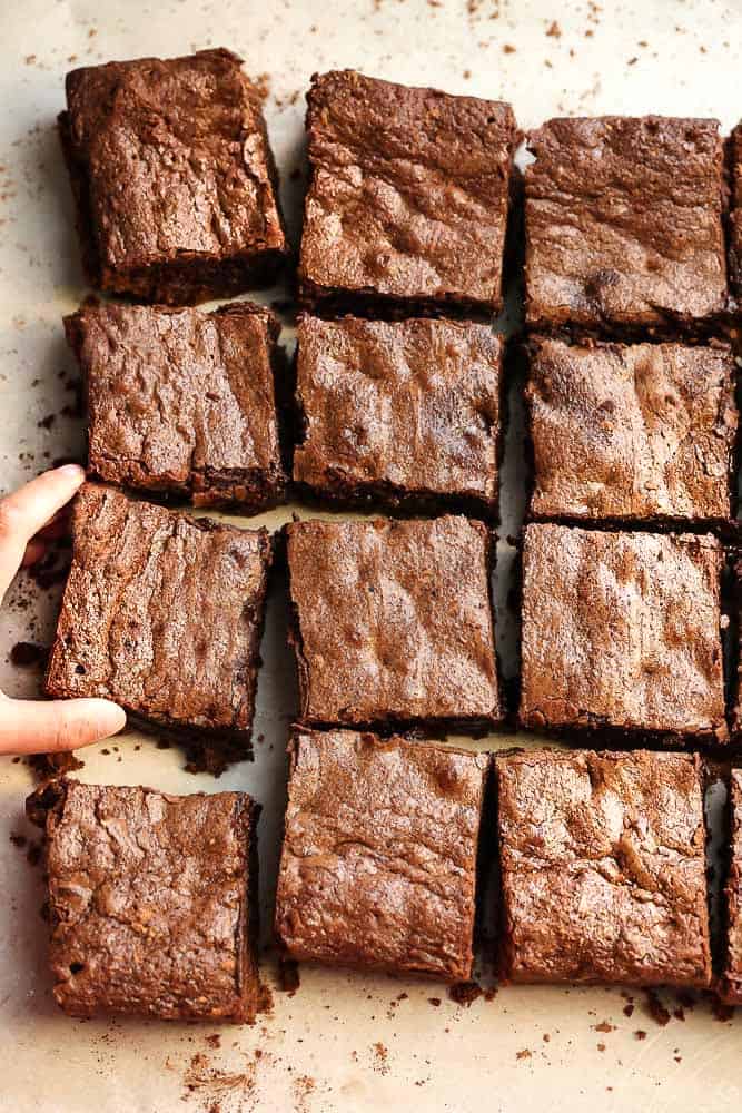 Twelve slices of the best fudgy brownies sitting on a table.