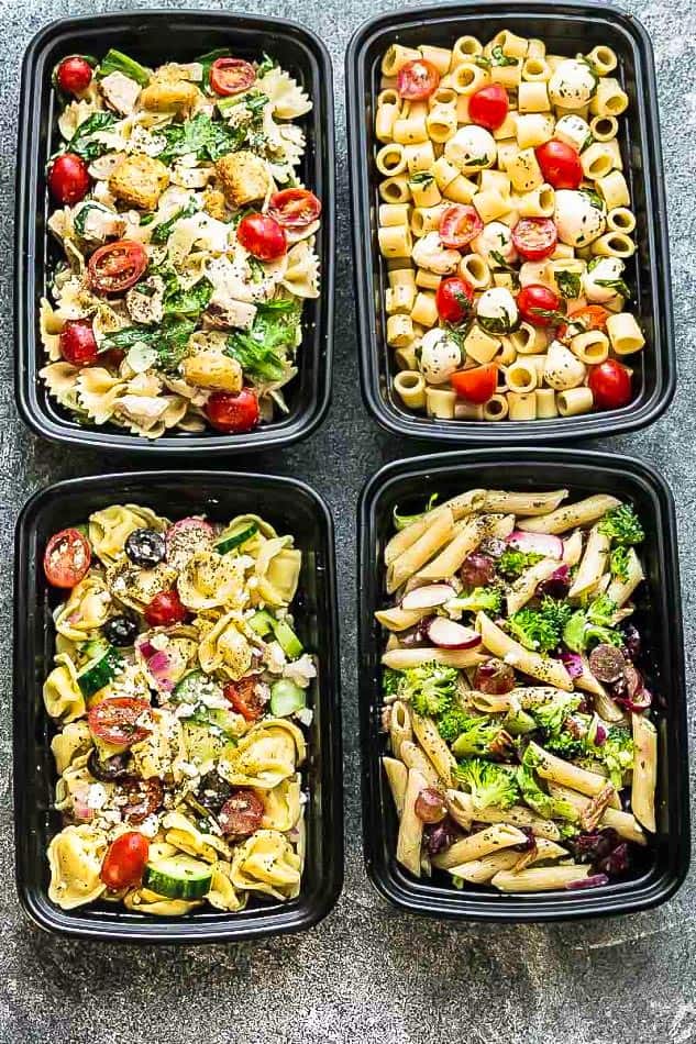 Top view of four varieties of pasta salad in meal prep containers