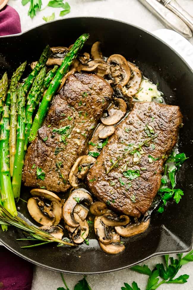 Garlic Steak with Herb Butter, Asparagus and Mushrooms - pan seared in a skillet plus "how to" tips to cook the best tender steak at home. This easy to customize recipe is also gluten free, low carb, paleo and keto friendly.