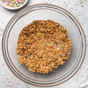 Top view of blended ingredients to make funfetti energy bites in a clear mixing bowl