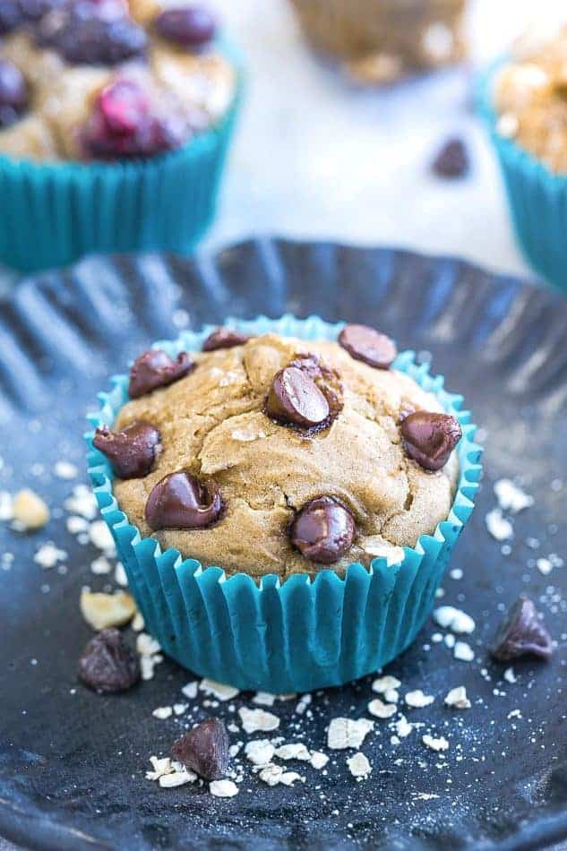 Close-up of a chocolate chip muffin in a blue paper muffin cup on a plate