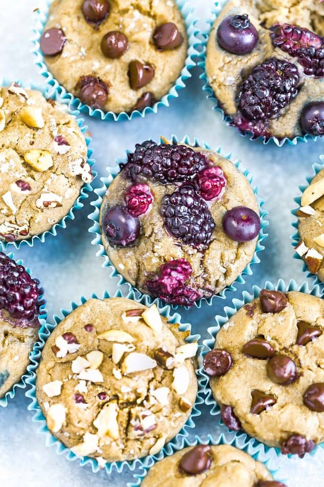 Top view of a variety of muffins with nuts, berries, and chocolate chips