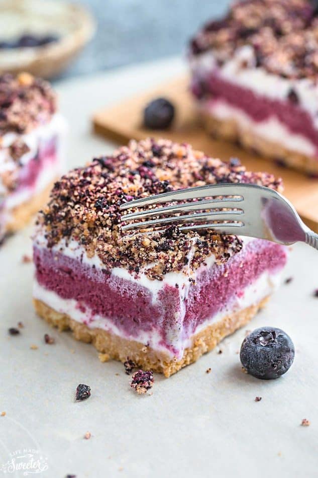 Close-up of a fork cutting into a layered Blueberry Frozen Yogurt Bar