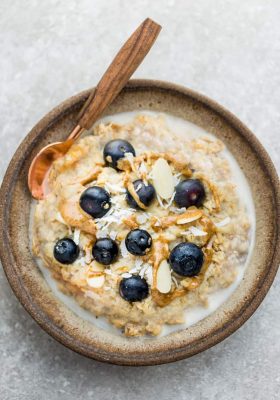 Top view of Blueberry Steel Cut Oats in a ceramic bowl with a spoon