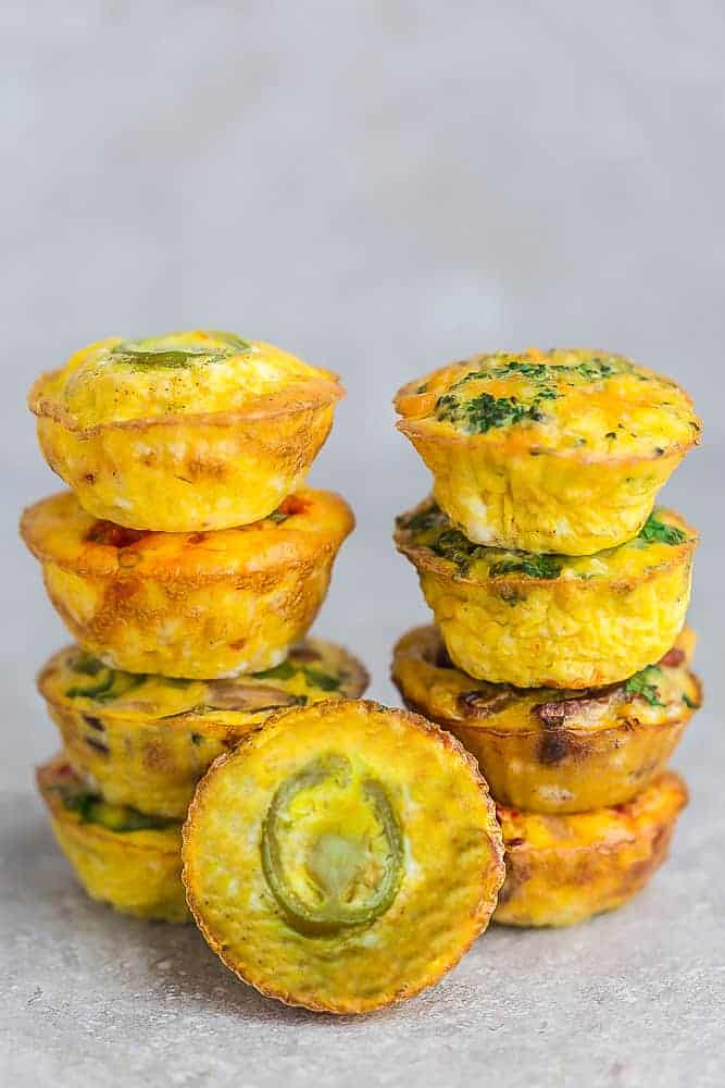 Two Side-By-Side Stacks of Breakfast Egg Muffins with a Jalapeno Popper Muffin in the Front