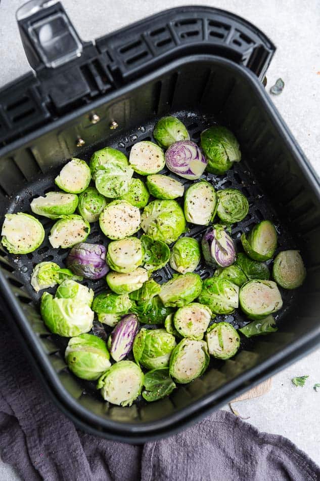 Top view of raw Brussels sprouts in an air fryer basket