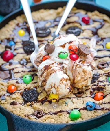 Candy Oreo Monster Skillet Cookie Pizza topped with ice cream with two spoons
