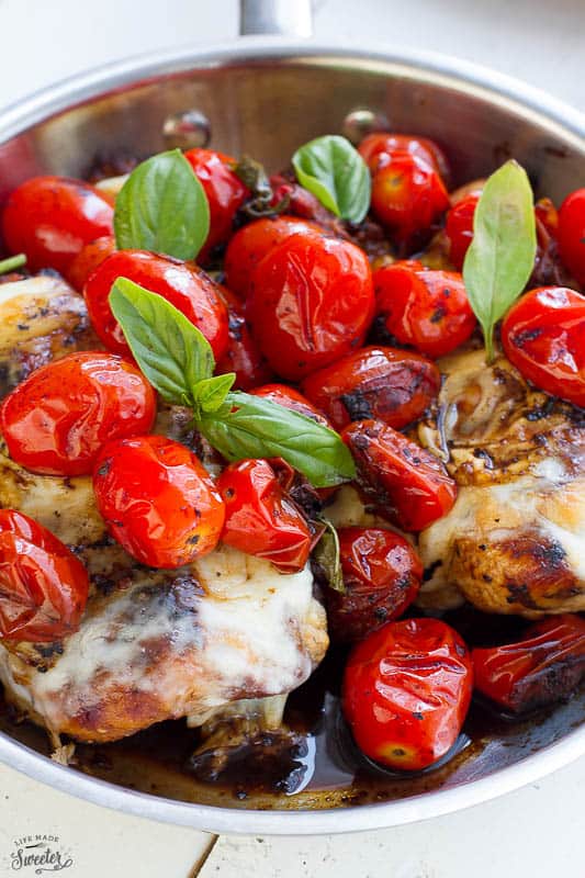 Caprese Chicken topped with melted cheese, blistered tomatoes and fresh basil