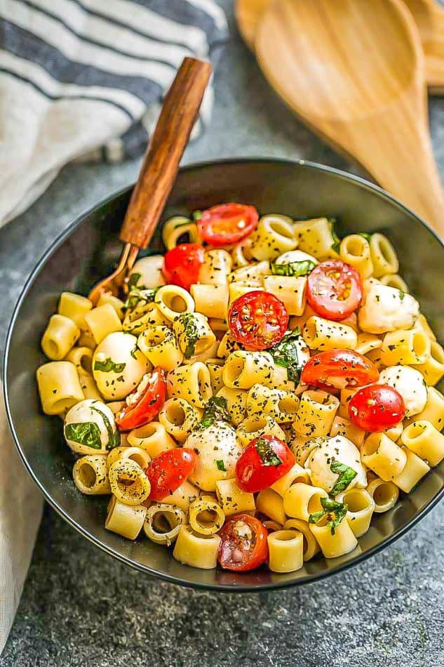 Caprese Pasta Salad - the perfect side dish to bring to summer potlucks, parties, Memorial Day / Fourth of July grillouts/barbecues. Best of all, it's so easy to make and easy to customize with your favorite toppings and homemade dressing. Perfect for Sunday meal prep and leftovers are delicious for school or work lunchboxes or lunchbowls.