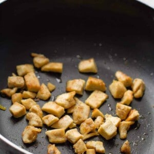 Stir-fried chicken cubes in a black wok