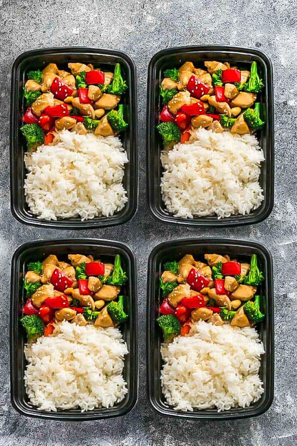 Four storage containers filled with white rice and equal portions of stir fry