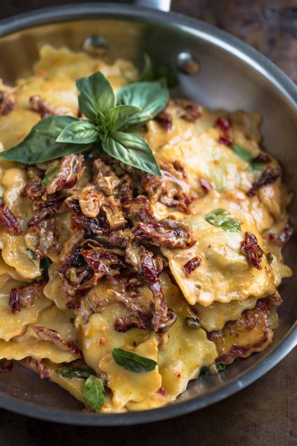 Overhead view of Cheese Ravioli with a Skinny Sun-Dried Tomato Alfredo Sauce in a skillet